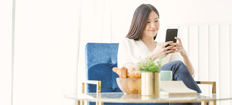 A lady is using her phone to do international transfer