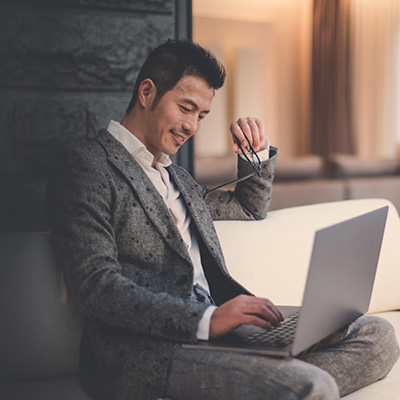 a gentleman using his laptop to check out SC mortgage plan, holding his glasses