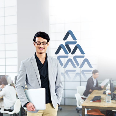 a businessman from a SME, holding his laptop for work in a small open office