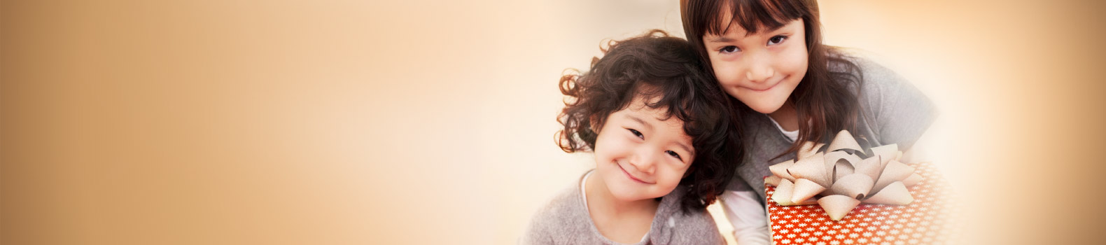 brother and sister holding a gift box and smiling
