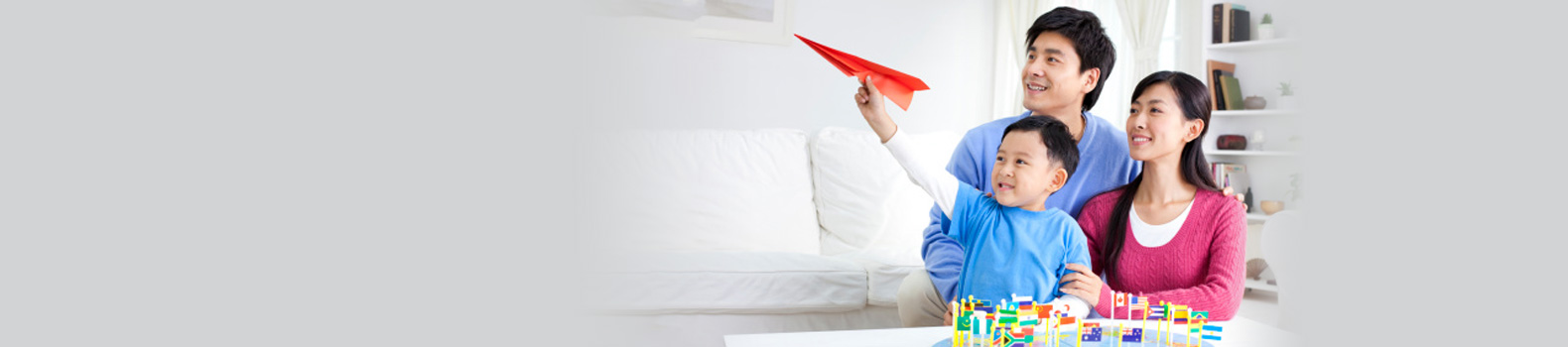 Parents with kid holding paper plane over a world map, image used for bank account upgrade
