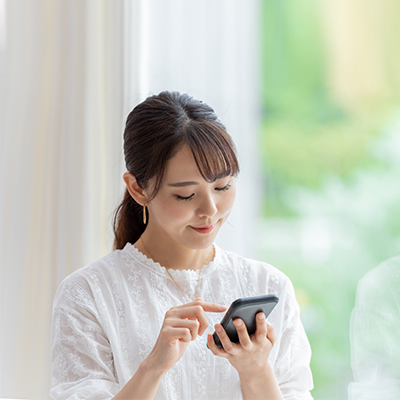 A lady in white shirt is using her mobile