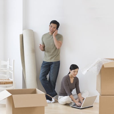 a couple are packing stuff in a flat