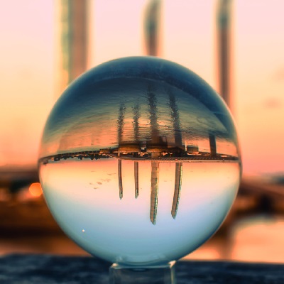 a crystal ball showing the reflection of the city view by the sea