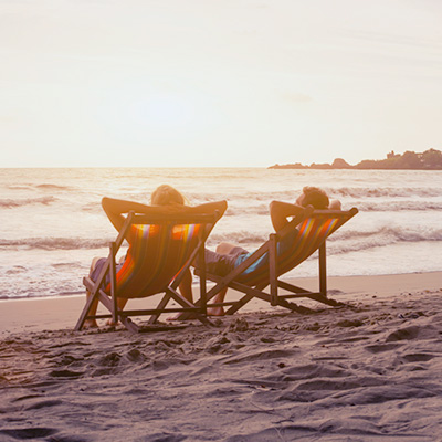 2 gentlemand sitting on beach chair and looking at the sea