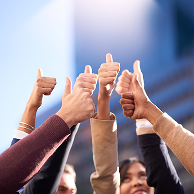 a group of people raising their hands with a thumb