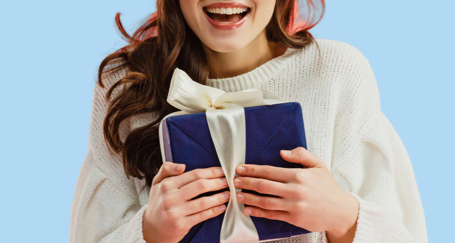 A lady in white sweater feeling ecstatic upon receiving a gift