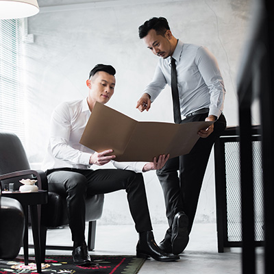 兩名男性正在將計畫書討論