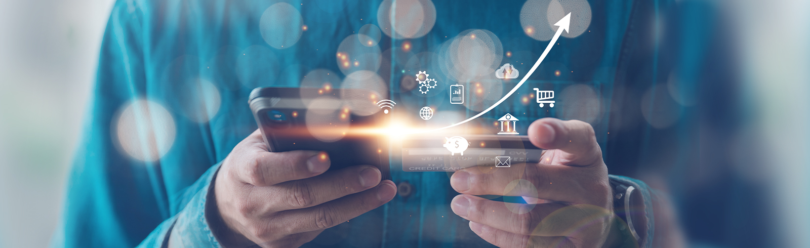 一名男士拿著信用卡和使用手機